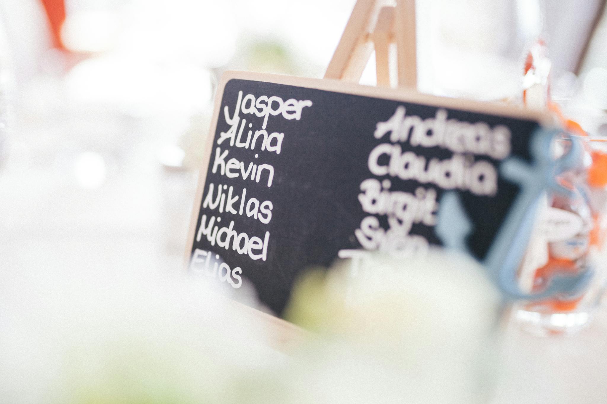 A decorative chalkboard displaying names at a refined indoor gathering.