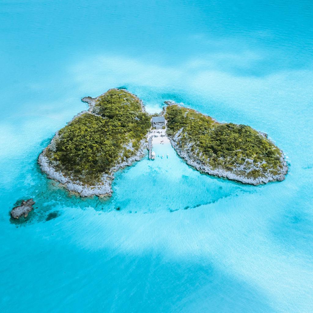 Stunning aerial view of a lush green island surrounded by turquoise water.