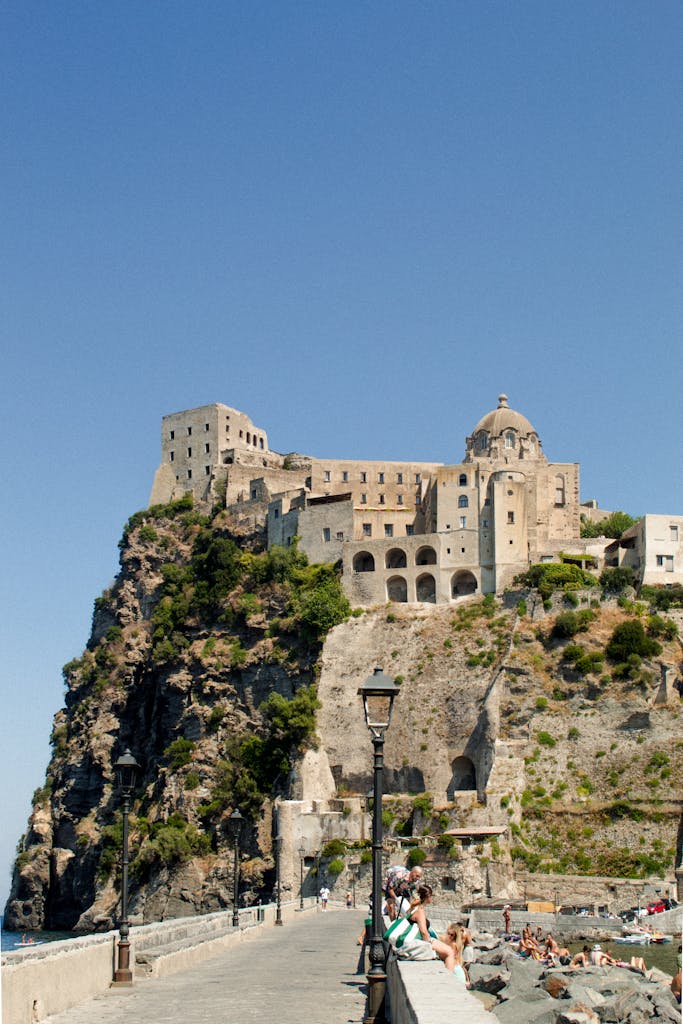 Dramatic coastal view of Aragonese Castle on a summer day in Ischia, Italy.