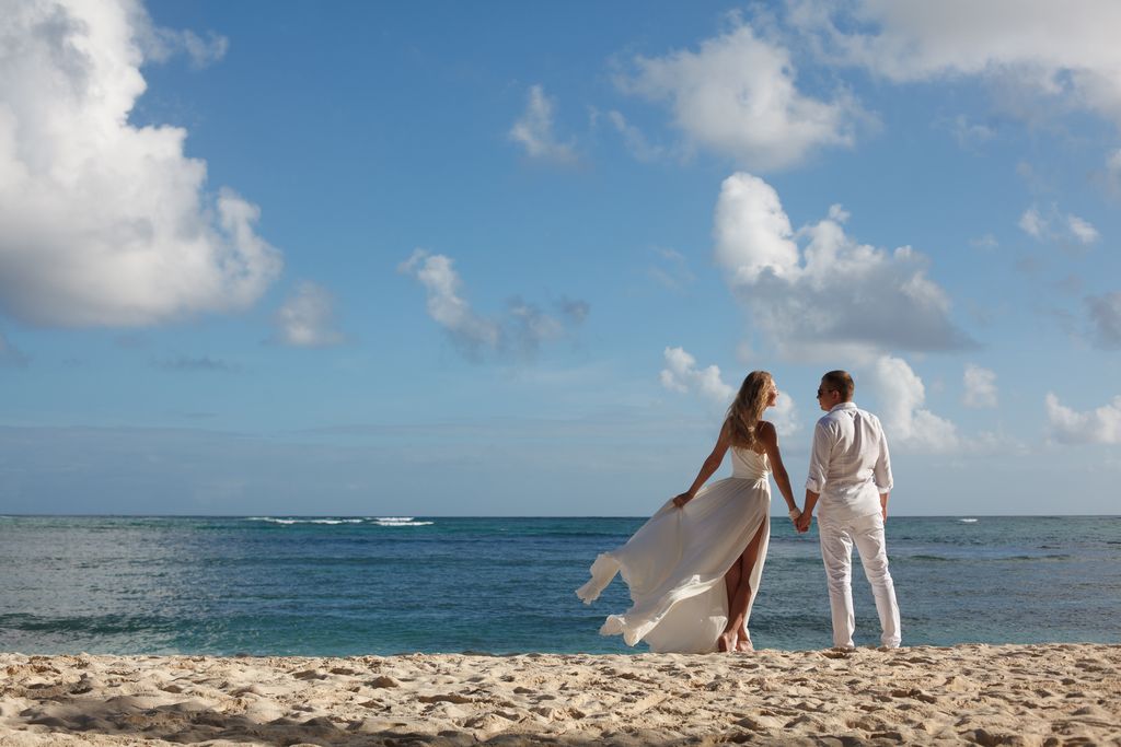 A couple enjoys their wedding day on a sunny Dominican Republic beach. Perfect for love and travel themes.