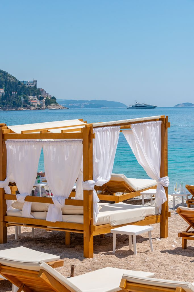 A beautiful beach cabana under a clear blue sky with ocean views, perfect for a summer vacation.
