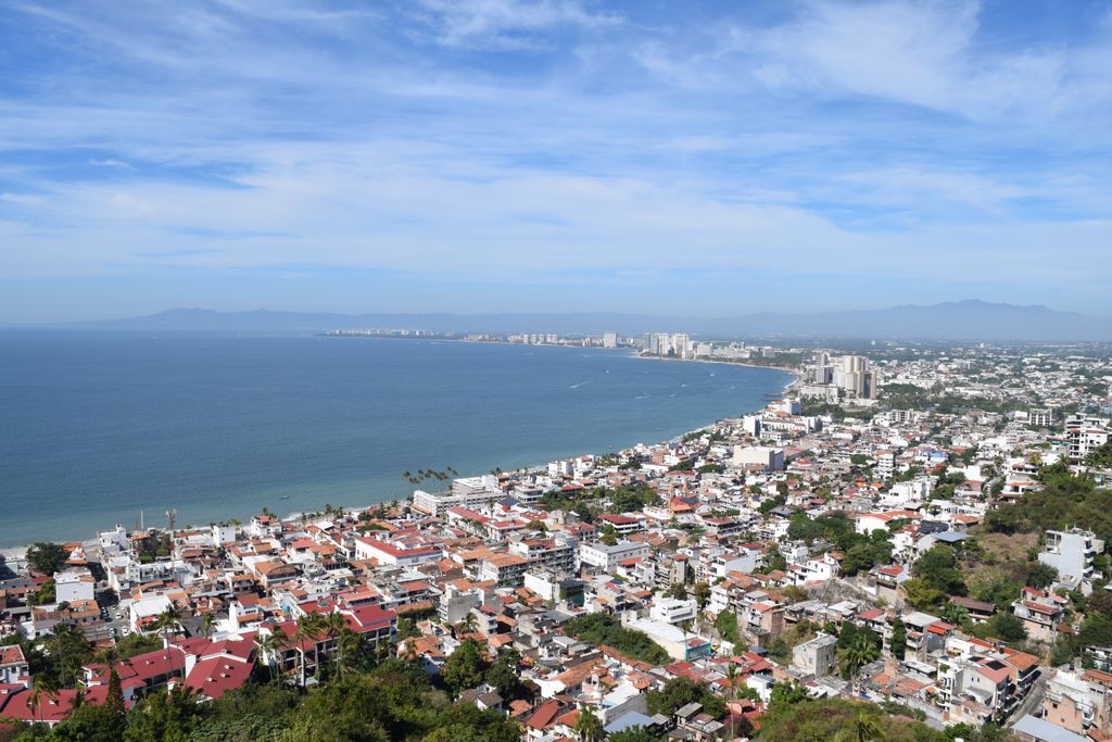 A tranquil day view of Puerto Vallarta's coastline with blue skies and city architecture.