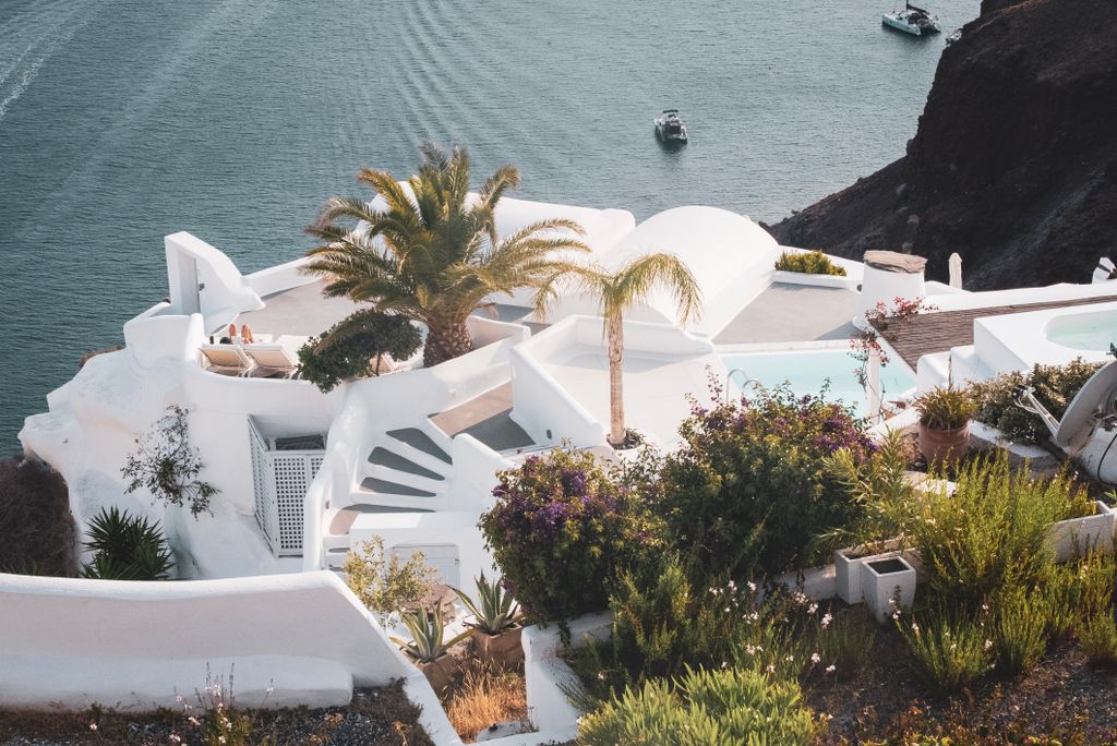 White-washed architecture in Fira, Greece, overlooking the serene Aegean Sea on a summer day.