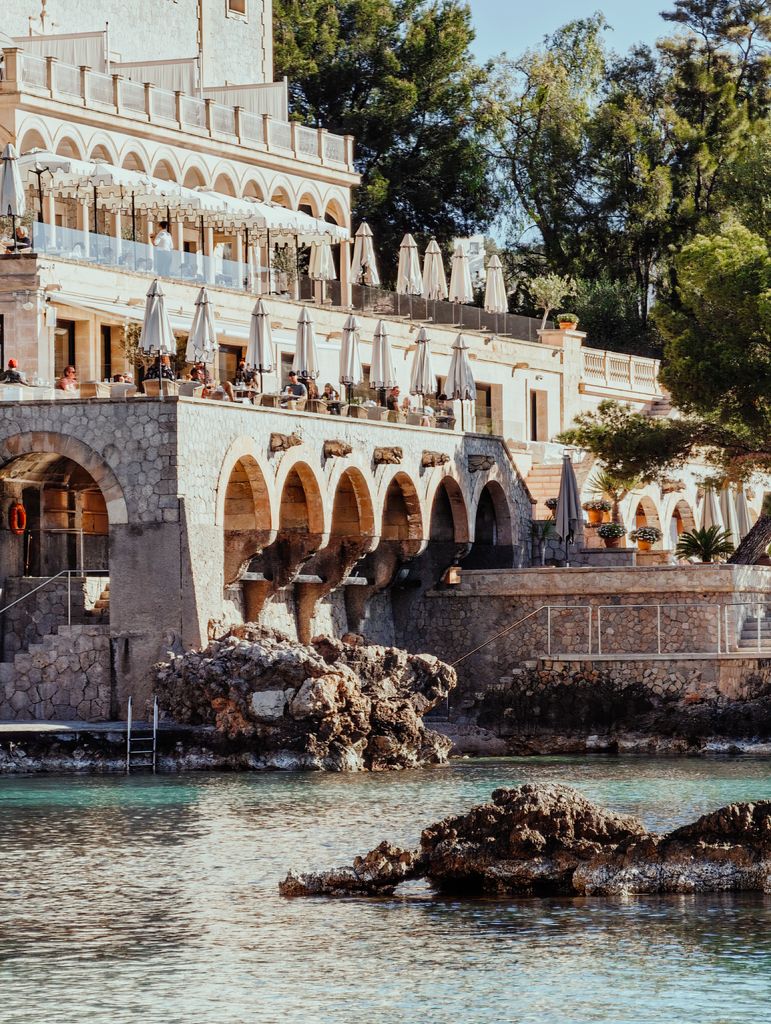 Charming coastal hotel with elegant arches overlooking the Mediterranean Sea, offering a scenic vacation spot.